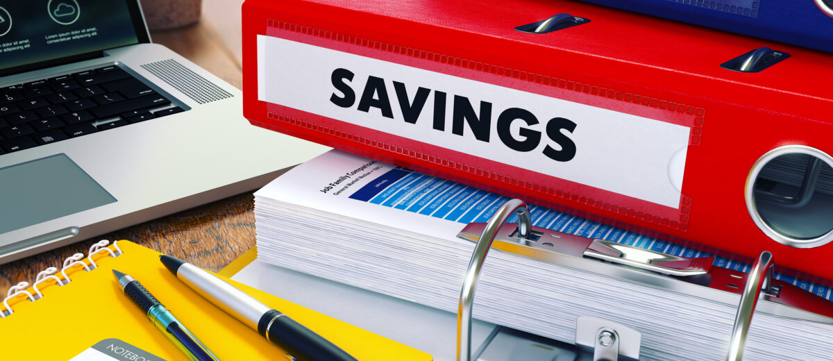 Savings - Red Ring Binder on Office Desktop with Office Supplies and Modern Laptop. Business Concept on Blurred Background. Toned Illustration.
