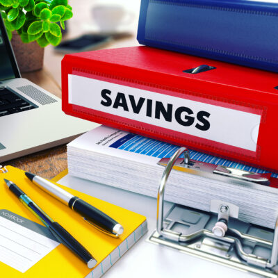 Savings - Red Ring Binder on Office Desktop with Office Supplies and Modern Laptop. Business Concept on Blurred Background. Toned Illustration.