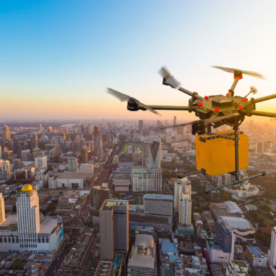 Drone transport flying with cardboard box above city, futuristi
